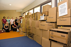 Children sitting on boxes of books 