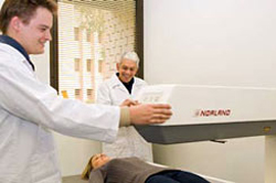 Dr Weisinger, rear, with colleagues Dr Denovan Begg, left, and Dr Lauren Stahl demonstrating equipment used to measure body fat.