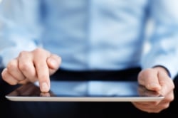 Close up photo of a man using an iPad