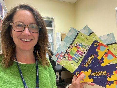 A Bouverie Centre team member holding family resources developed to support families where a parent experiences mental health concerns.