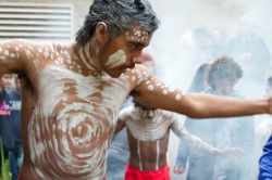 aboriginal man in middle of ceremony with white traditional paint on body