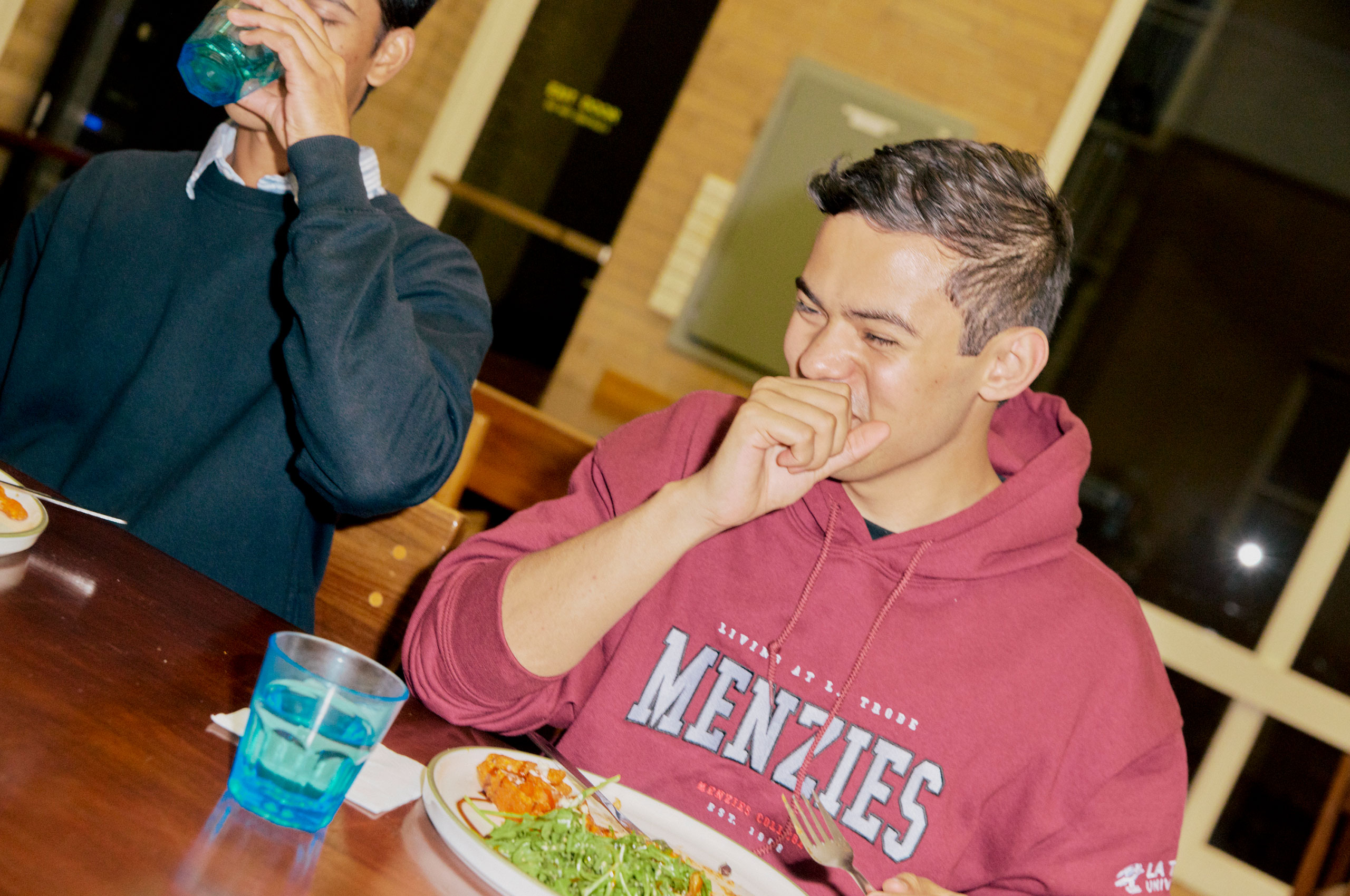 Image of student in Menzies College hoodie eating