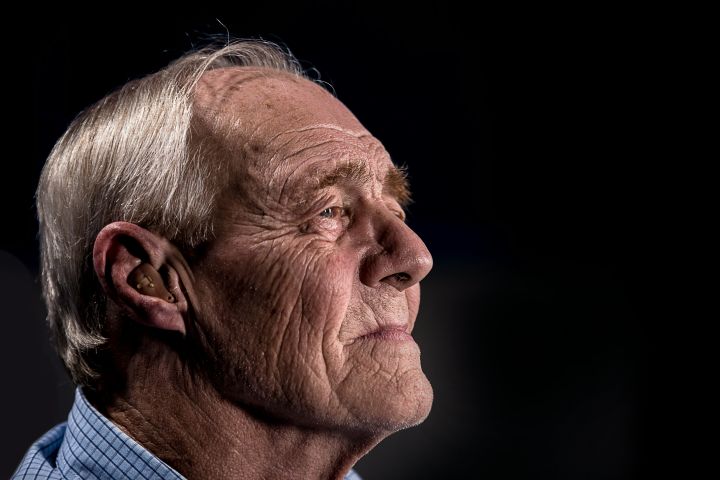 an image of an elderly man's side profile looking into the distance