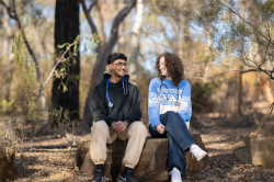 Two biomedical science students wearing stethoscopes sitting together outdoors.