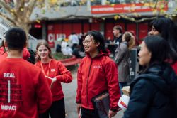 Campus ambassadors chat with students outdoors during a La Trobe University event.