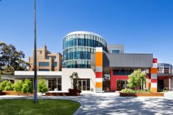 A architecturally designed four storey building at the Bendigo Campus, with glass, red, grey, and orange highlights.