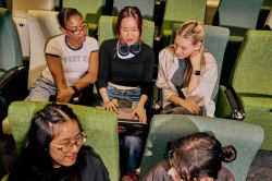 Students studying together with laptops in a La Trobe University lecture theatre.