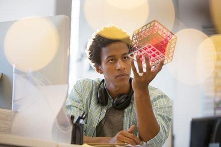 Man wearing headphones holding a cube.