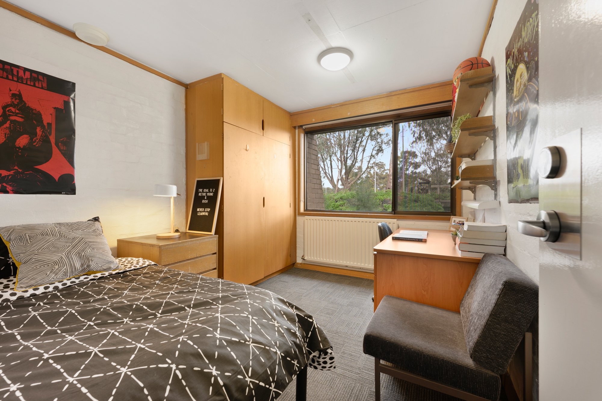 Single bed, chair and desk, showing a room at Chisholm College.