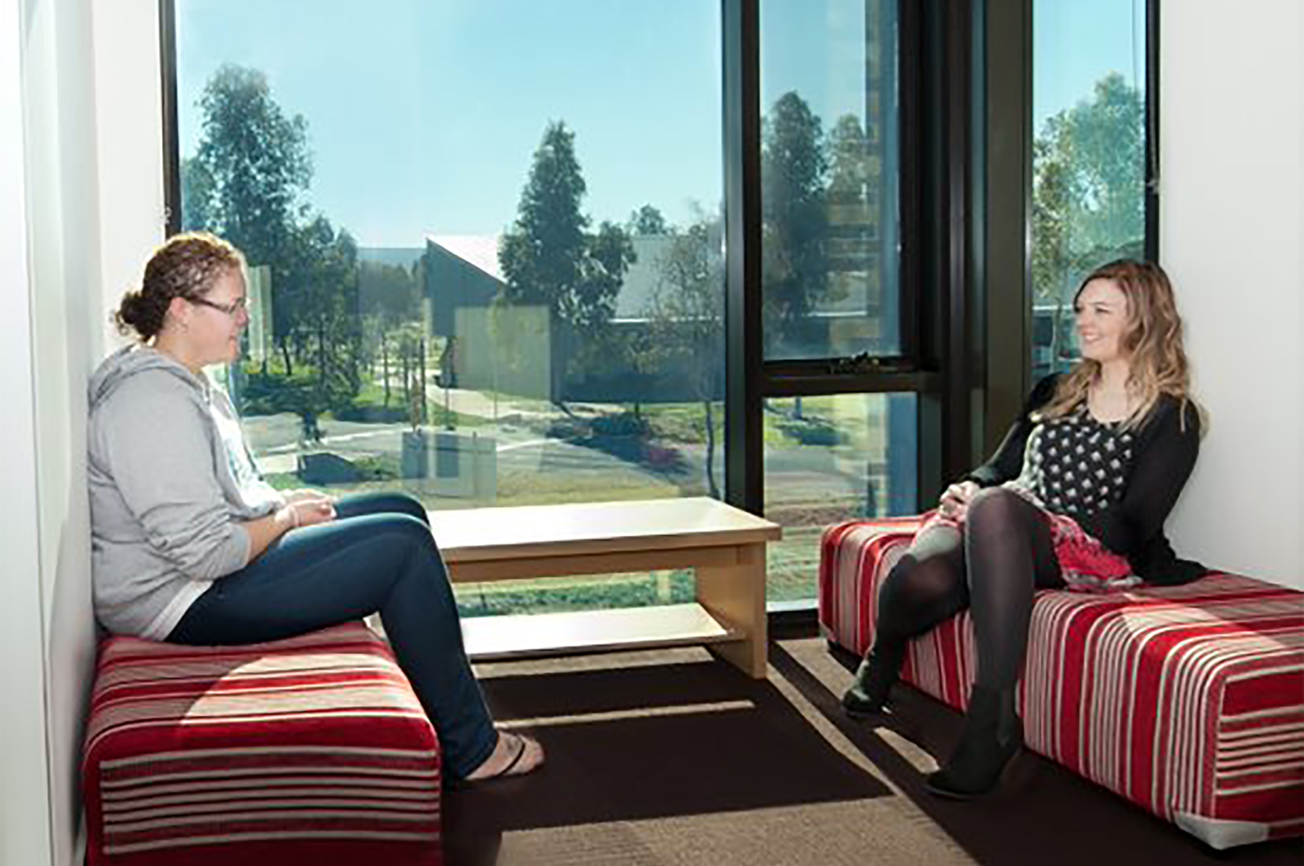 Two woman talking with one another within the student accommodation.