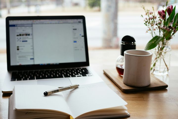 Open notebook in front of a laptop