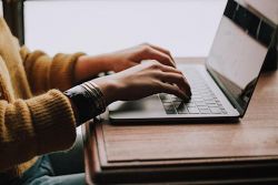 Typing on a laptop at a desk