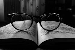 A pair of glasses resting on an opened book