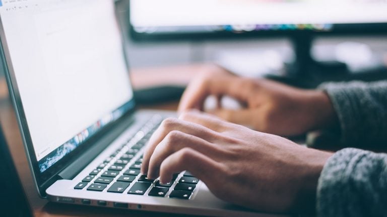 Someone typing at a laptop