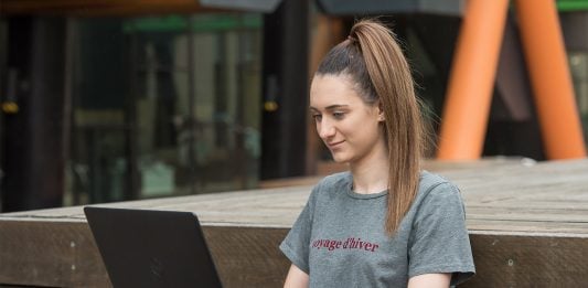 Student sitting outside using a laptop