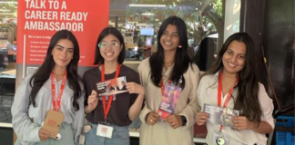 Career Ready Ambassadors holding flyers and standing at a booth