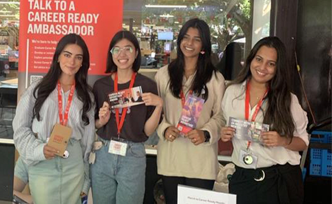 Career Ready Ambassadors holding flyers and standing at a booth