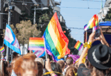 Picture of a crowd of people holding and raising rainbow flags, symbol of the homosexual struggle, during a gay demonstration. The rainbow flag, commonly known as the gay pride flag or LGBT pride flag, is a symbol of lesbian, gay, bisexual and transgender (LGBT) pride and LGBT social movements. Other older uses of rainbow flags include a symbol of peace.