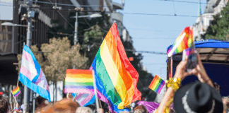 Picture of a crowd of people holding and raising rainbow flags, symbol of the homosexual struggle, during a gay demonstration. The rainbow flag, commonly known as the gay pride flag or LGBT pride flag, is a symbol of lesbian, gay, bisexual and transgender (LGBT) pride and LGBT social movements. Other older uses of rainbow flags include a symbol of peace.