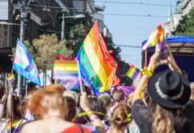 Picture of a crowd of people holding and raising rainbow flags, symbol of the homosexual struggle, during a gay demonstration. The rainbow flag, commonly known as the gay pride flag or LGBT pride flag, is a symbol of lesbian, gay, bisexual and transgender (LGBT) pride and LGBT social movements. Other older uses of rainbow flags include a symbol of peace.