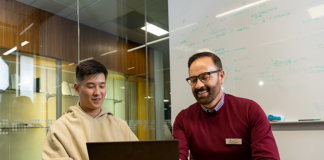 Student Advisor helping a student. Both are looking at a laptop.