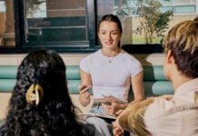 A student sitting and talking to other students