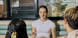 A student sitting and talking to other students