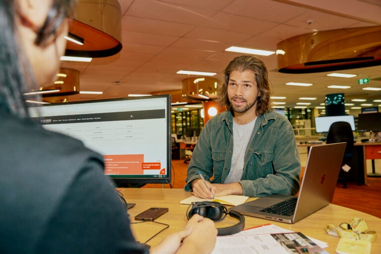 A student talking to an advisor at a desk
