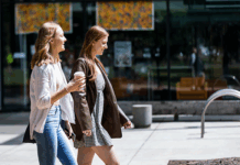 Two students walking and one is holding a coffee