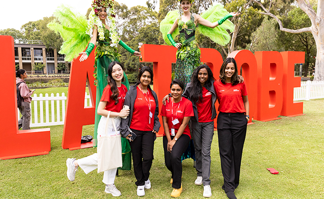 Main O Week image_WordPress Article (650 x 400) Students standing in front of La Trobe signage at O Week