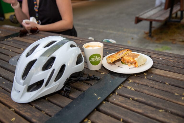A bike helmet sitting next to breakfast food on a table.