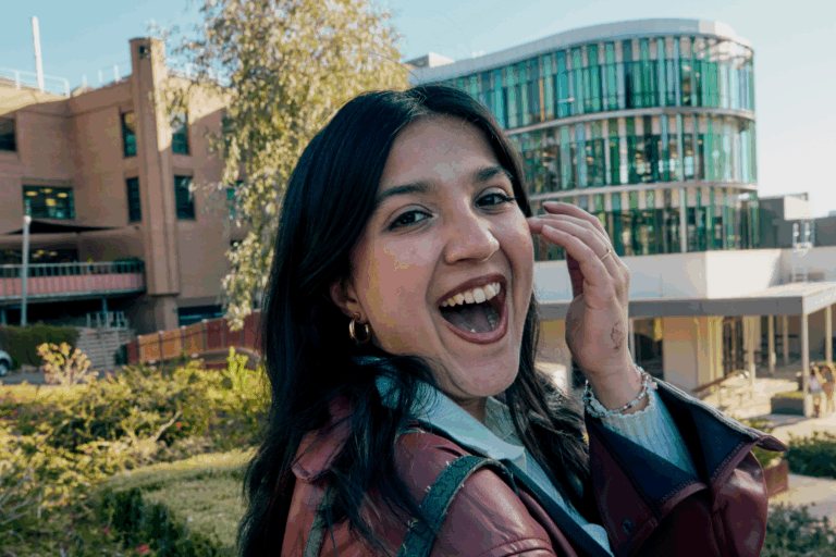An excited student smiling and looking at the camera