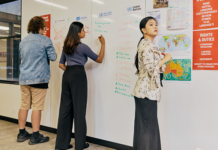 The ultimate survival guide to group assignments Students working on a group assignment, drawing on board