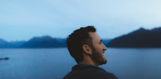 A young man smiling and looking out in the distance