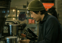 A barista making coffee wearing a beanie