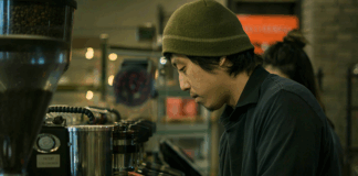 A barista making coffee wearing a beanie