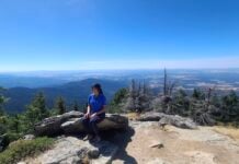 A woman looking out at a beautiful view from the top of a hike.