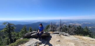 A woman looking out at a beautiful view from the top of a hike.