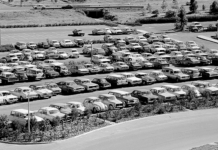 A vintage black and white photo of cars parked at a La Trobe campus