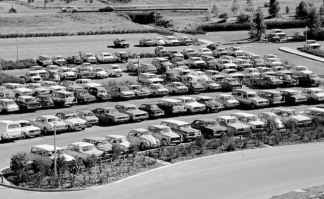 A vintage black and white photo of cars parked at a La Trobe campus