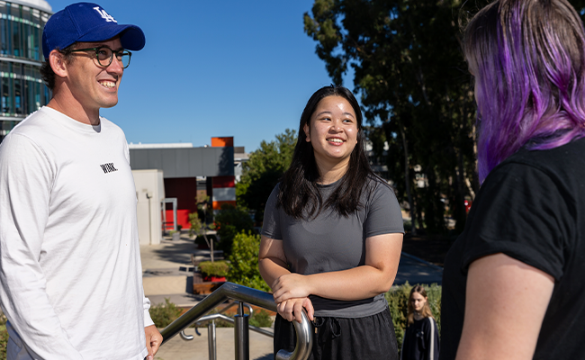 Three students chatting and laughing outside