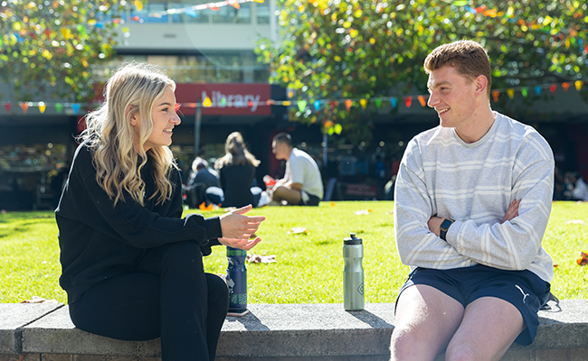 Two students in conversation sitting in the Agora