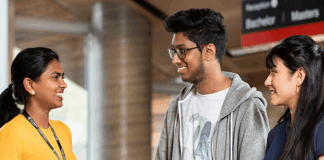Three students talking and reading books