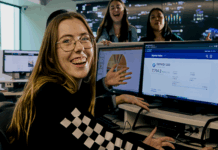 La Trobe business student smiling at camera with computer in background