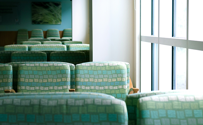 An empty wait room with green chairs