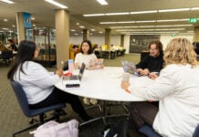 Students sitting at a table with their laptops