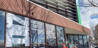 Two students walking outside the Northern Study Hub building