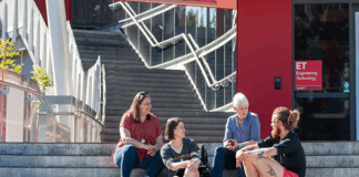 A group of students and staff sitting on the stairs