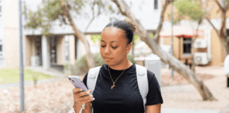 A student walking looking at their phone