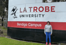 Student Justine standing in front of La Trobe sign in Bendigo